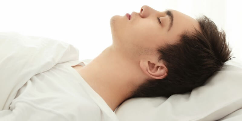 Jeune homme fatigué dormant dans son lit